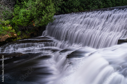 waterfall at belfountain conservation area Ontario Canada with trees, rocks, bridge, and long exposure © DanielCarson