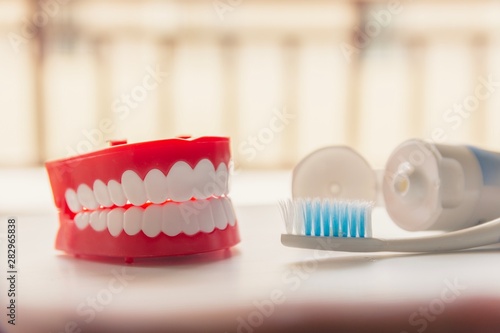 Close up Denture with toothpaste Toothbrush on blurred background.Metaphor for oral, dentures jaw toothy healthcare protect.