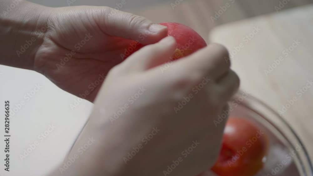 Peel the boiled tomato little by little. close up.Handmade Tomato source recipe Peel the boiled tomato little by little. close up.Handmade Tomato source recipe