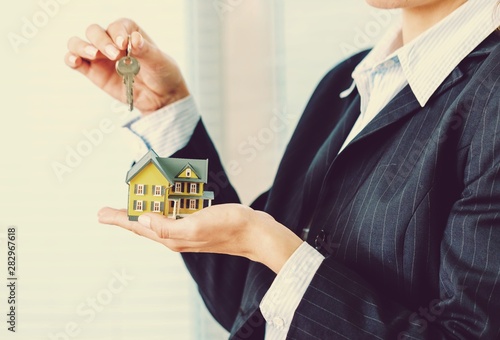 House in human hand on background