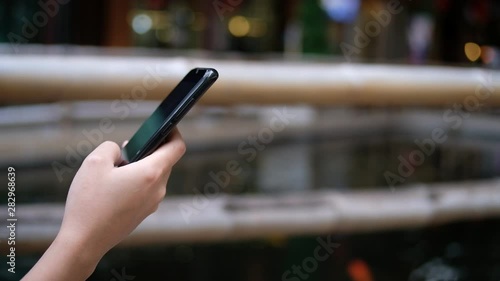 Cropped hand of woman used mobile phone blurred background