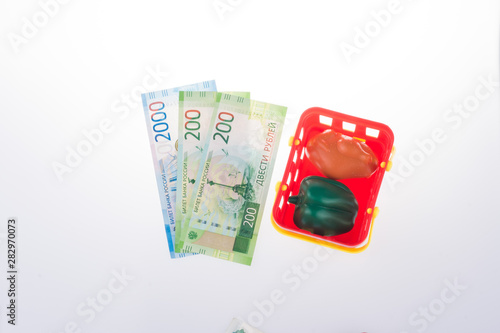 ruble banknotes, plastic shopping basket with toy plastic food, Russian currency on a white background. concept of shopping or sales