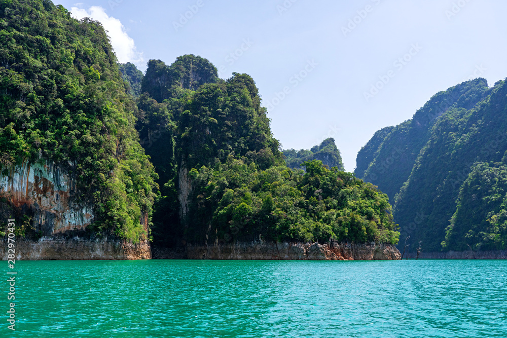 Fototapeta premium Green forest on limestone mountains in blue lake