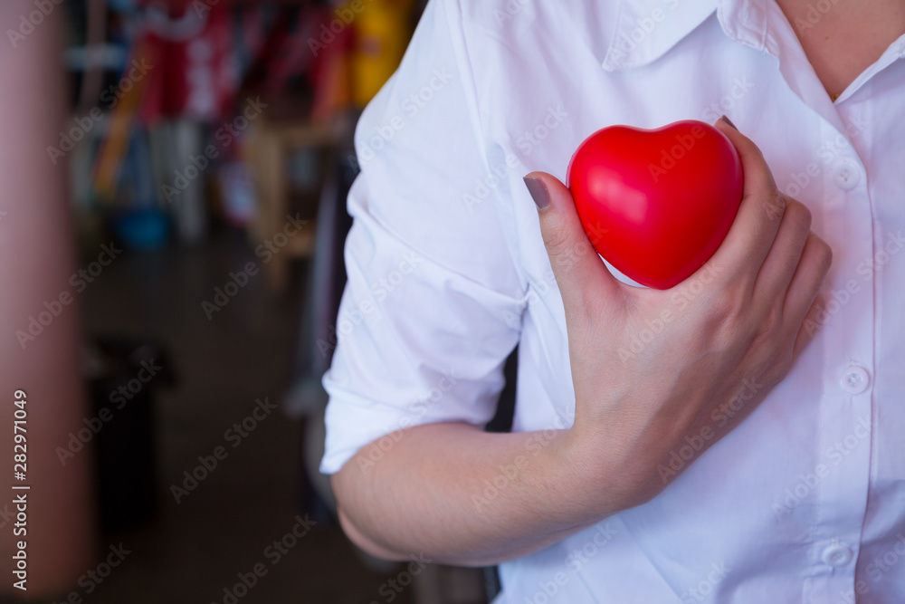 woman hold red heart and wearing white shirt