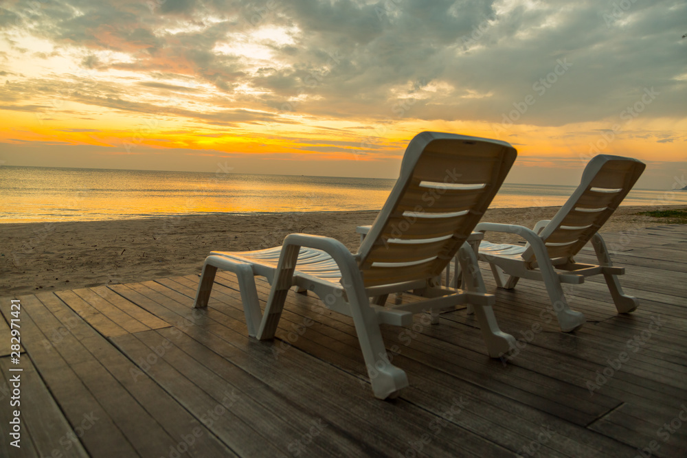 White chairs on the beach before sunset background