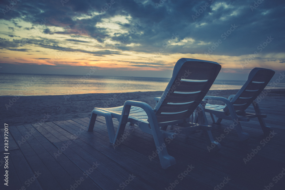 Vintage of White chairs on the beach before sunset