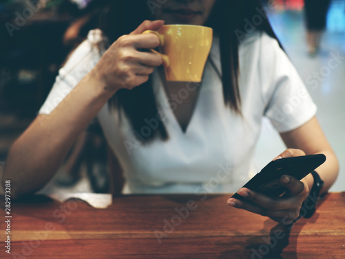 woman holding a coffee cup and smartphone