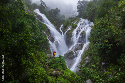 The girl in red sweater touring on Pi-tu-gro waterfall  Beautiful waterfall in Tak  province  ThaiLand.