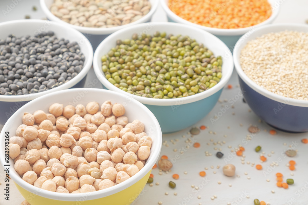 Different types of legumes in small pussies on a white background