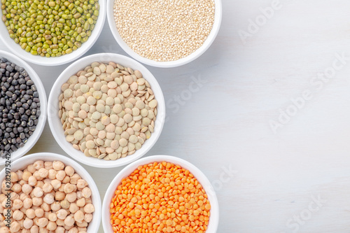 Different types of legumes in small pussies on a white background