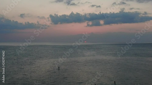 drone aerial of group of paddleboarders in the gulf of mexico at sunset photo