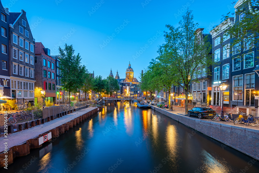 Saint Nicholas Church with Amsterdam skyline at night in Netherlands