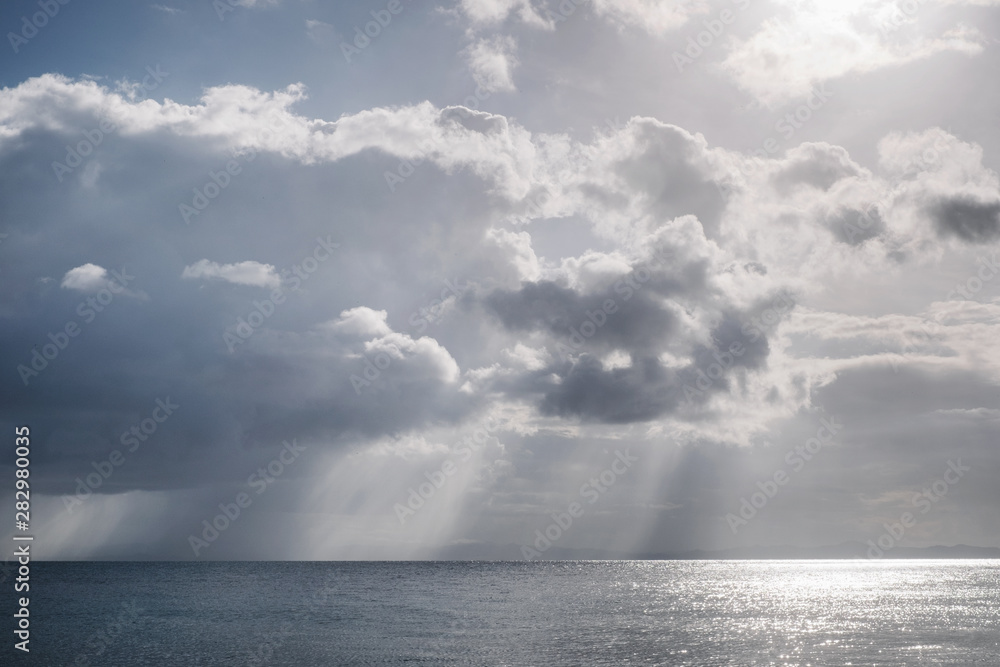 Storm and rain through sunbeams at sea near Vieques and Puerto Rico islands