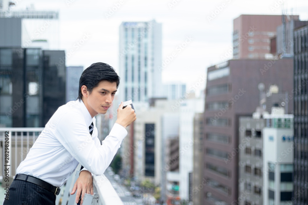 屋上で休憩を取るビジネスマン