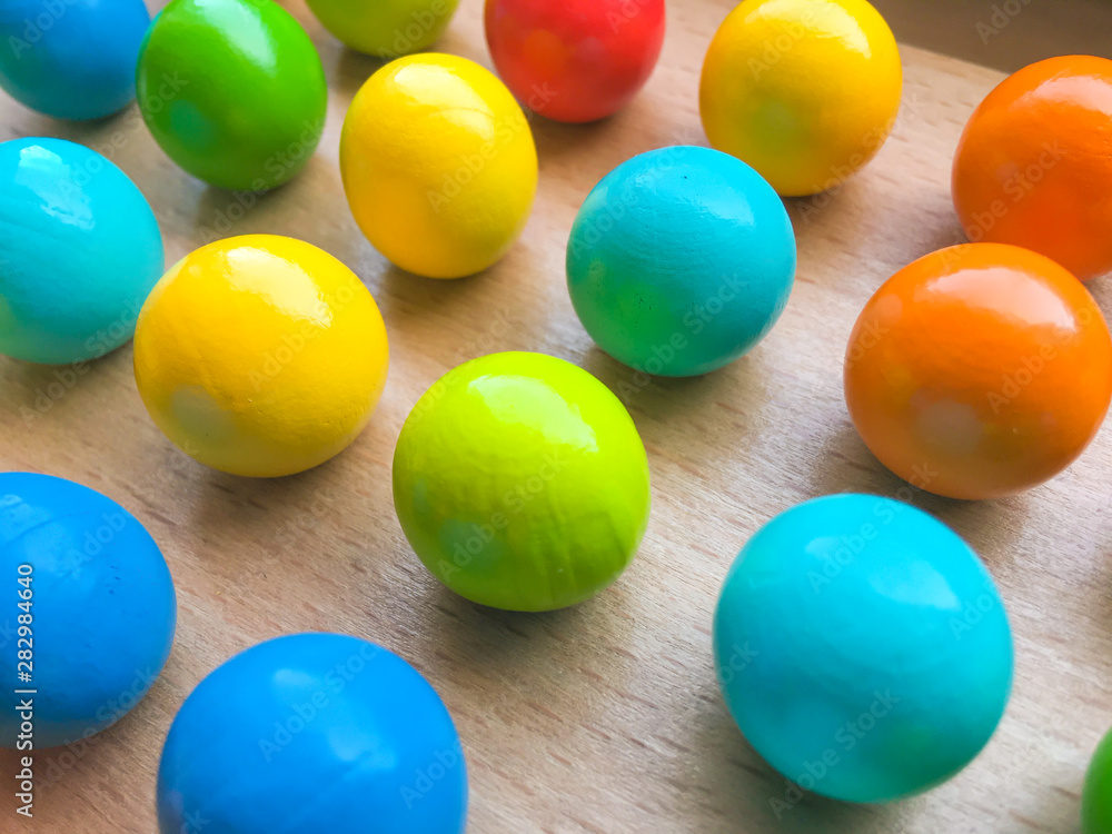 colored toy balls on a wooden table. educational toys for children. background for business colored toy balls on a wooden table. educational toys for children. background for business