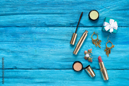 Makeup beauty cosmetic on a blue wooden table flat lay background with a copy space.