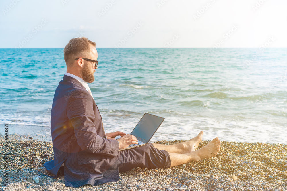 Businessman working with computer on the beach Businessman working with computer on the beach