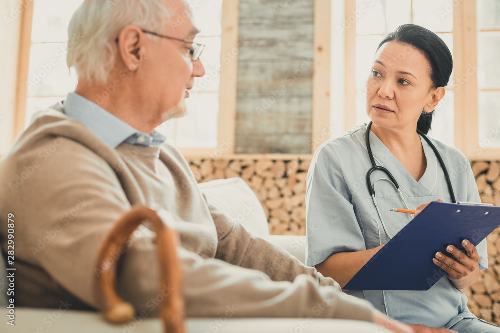 Obraz premium Attentive female with dark hair writing down indications