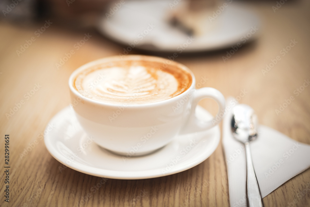 Fototapeta Hot coffee cappuccino latte art on wooden background