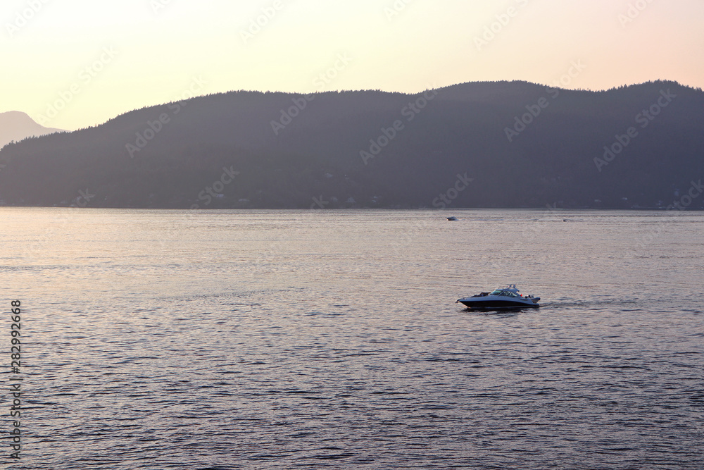 View of sunset and boats off coast of Whytecliff Park in West Vancouver BC, Canada