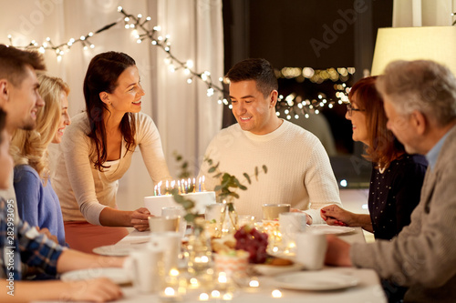 celebration and people concept - happy family with cake having birthday party at home