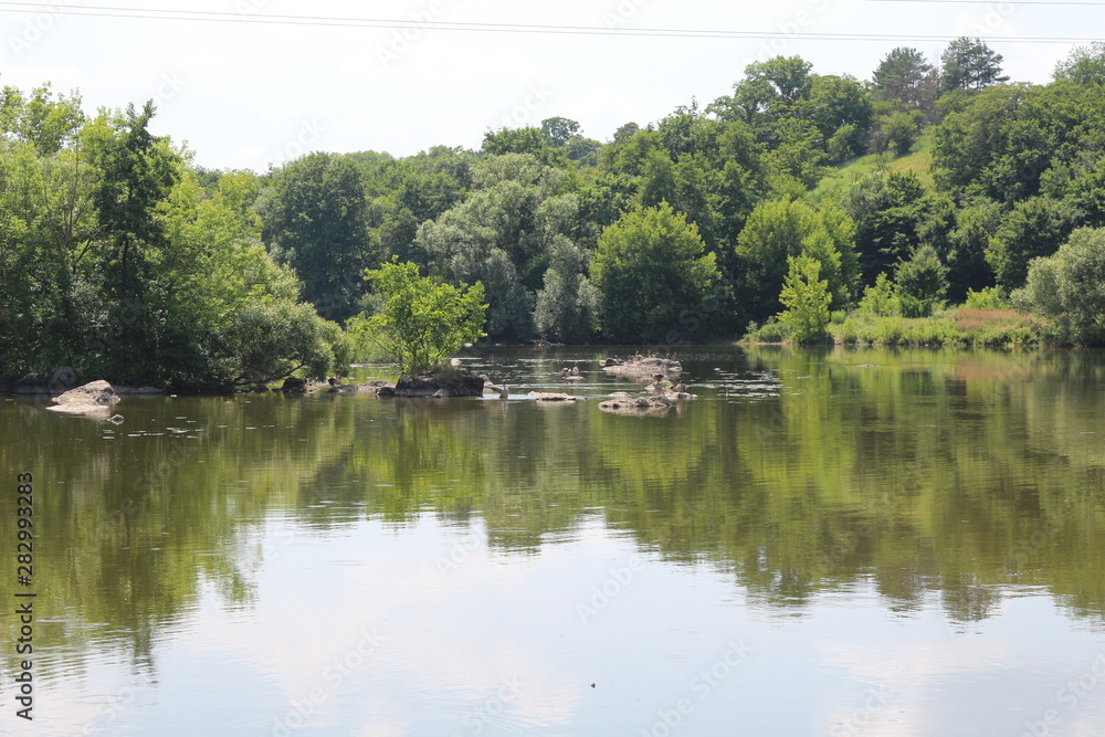 Obraz premium A calm river flows along the plain shores