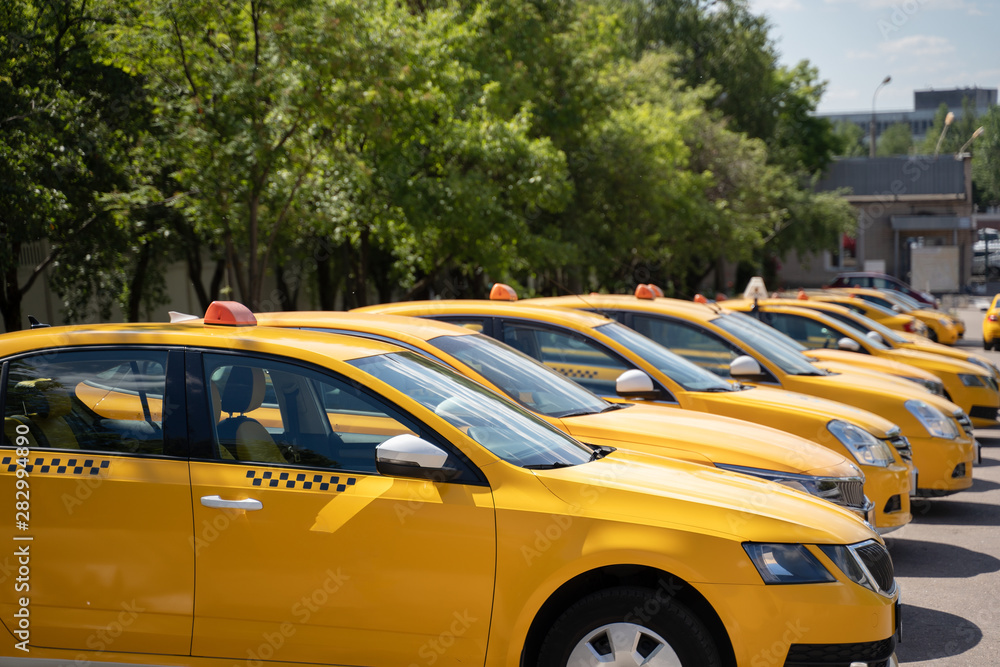 Photo of several yellow taxi on street in summer - obrazy, fototapety, plakaty 