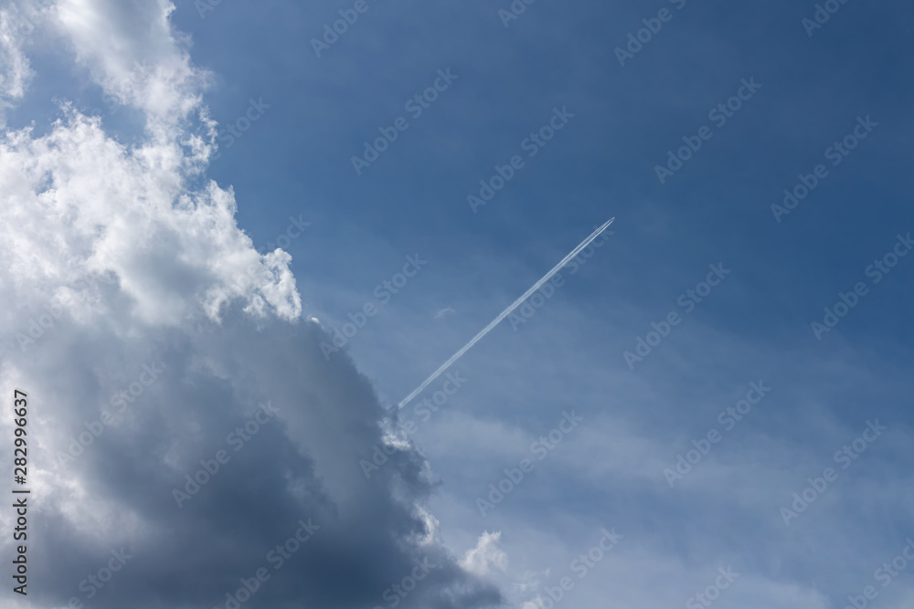 Bright blue sky with backlit cloud and an airplane shooting thru it Bright blue sky with backlit cloud and an airplane shooting thru it