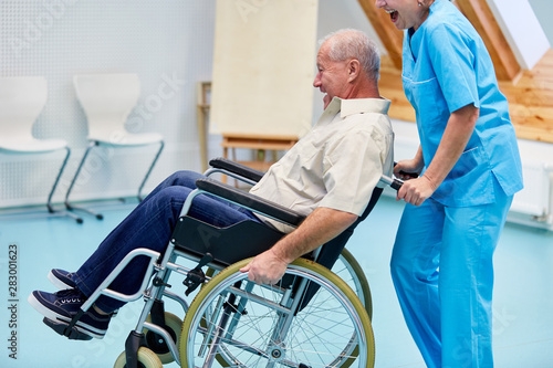 Pflegekraft albert mit einem Senior im Rollstuhl