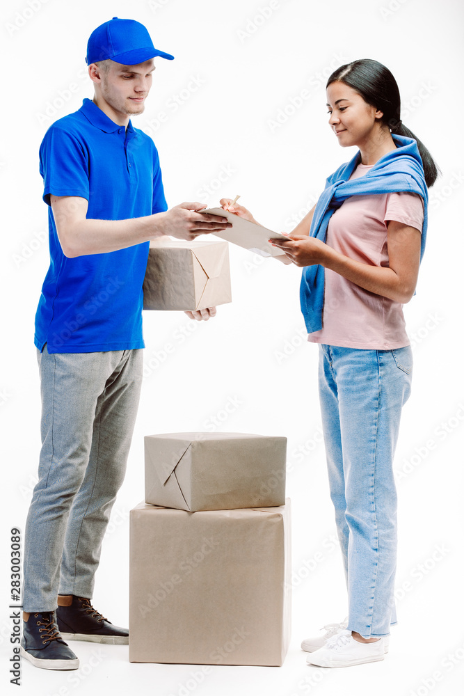 Postman checks the adress on the parcel with the help of the woman client. Postman checks the adress on the parcel with the help of the woman client.