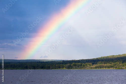 Rainbow divies sky northern BC taiga lake Canada