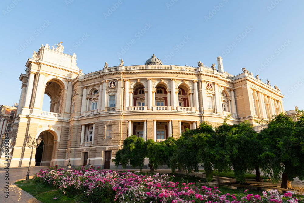 Ukraine, Odessa, 13th of June 2019. Side view of the national academic opera building and the park with beautiful flower beds during a sunny day