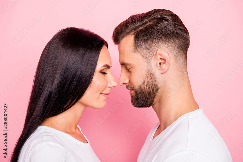 Close-up profile side view portrait of his he her she two nice-looking attractive lovely charming gentle cheerful dreamy calm peaceful spouses isolated over pink pastel background