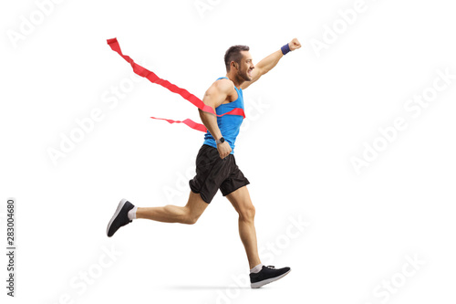Male athlete on the finish line of a race gesturing happiness