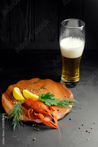 lobster with beer lemon lime and dry pepper on black background top view