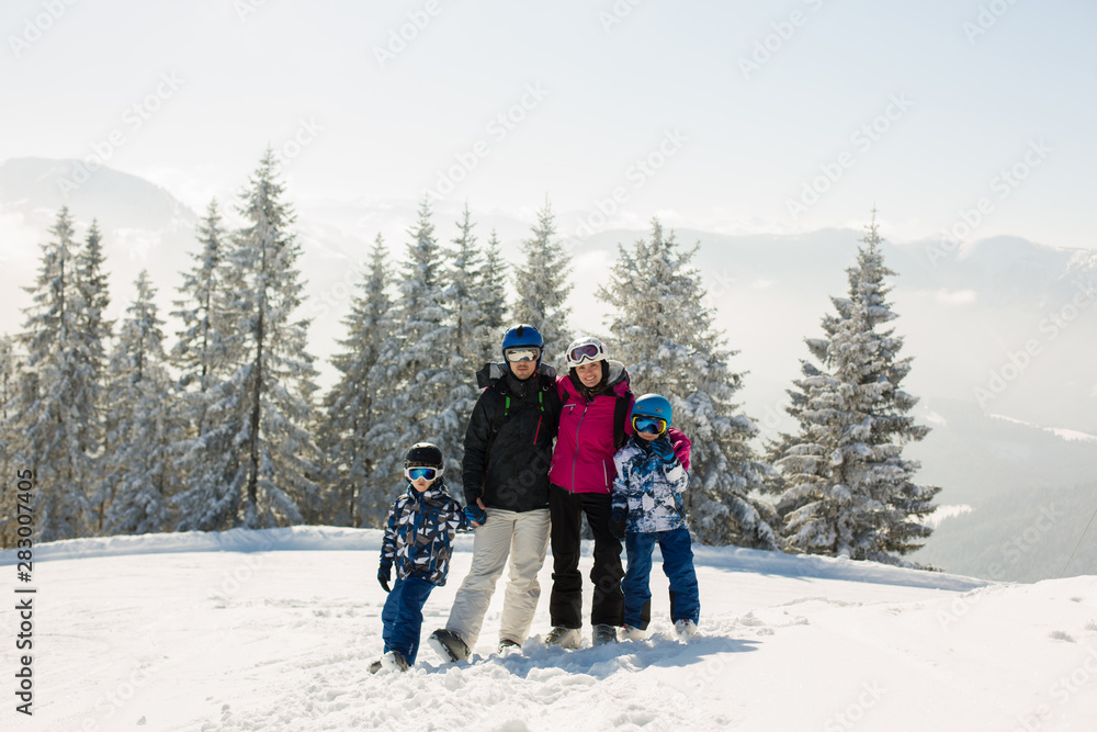 Beuatiful family with two kids, skiing on a sunny day in scenery austrian Alps