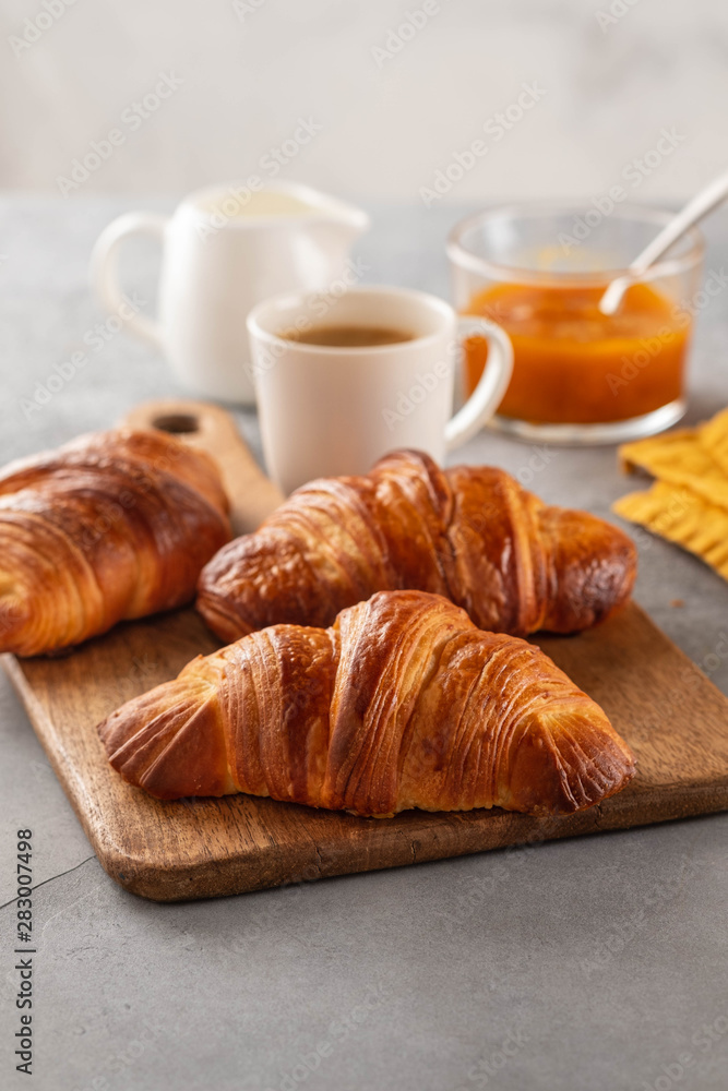 Freshly baked croissants and coffee cup on grey table. Copy space.