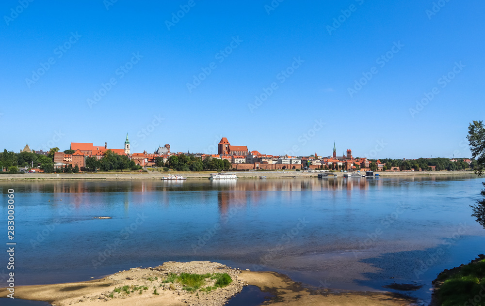 Fototapeta premium Panoramic view of Torun city and Wisla river in sunny day. Poland, summer 2019