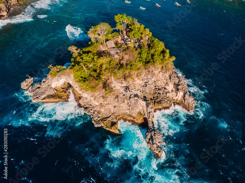 Ocean with waves and rocky island at Nusa Penida. Aerial view