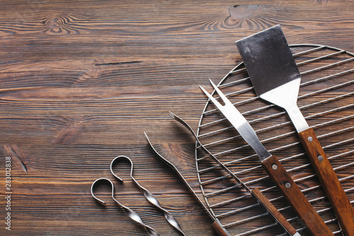 New metallic barbecue utensils on wooden background photo