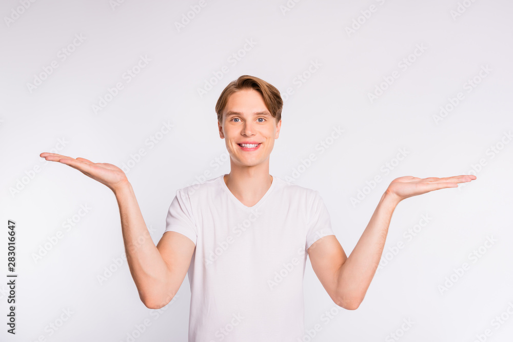 Attractive guy holding both arms with sale price products wear casual outfit isolated white background Attractive guy holding both arms with sale price products wear casual outfit isolated white background