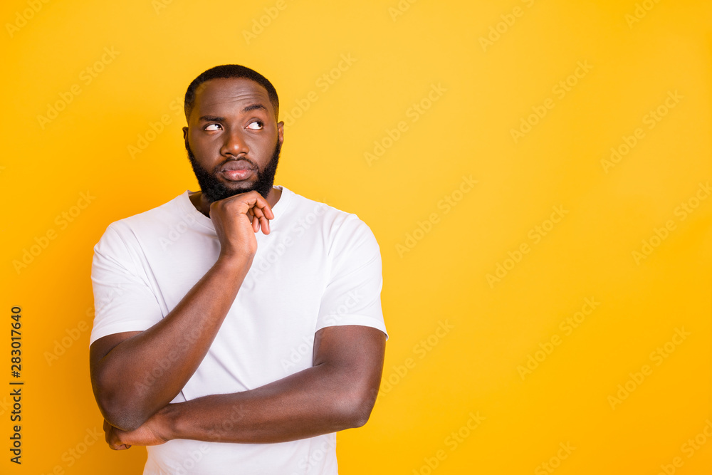 Close up photo of dark skin guy looking up empty space not sure with decision wear casual outfit isolated yellow background Close up photo of dark skin guy looking up empty space not sure with decision wear casual outfit isolated yellow background