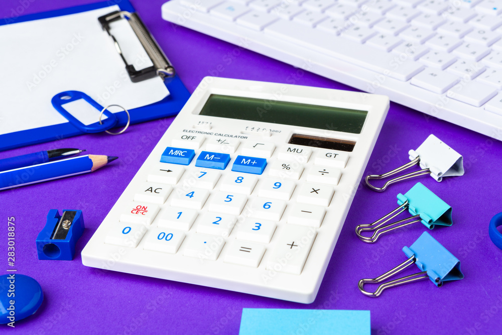 Composition of office lifestyle items on purple background, computer keyboard office supplies on desk in office Composition of office lifestyle items on purple background, computer keyboard office supplies on desk in office