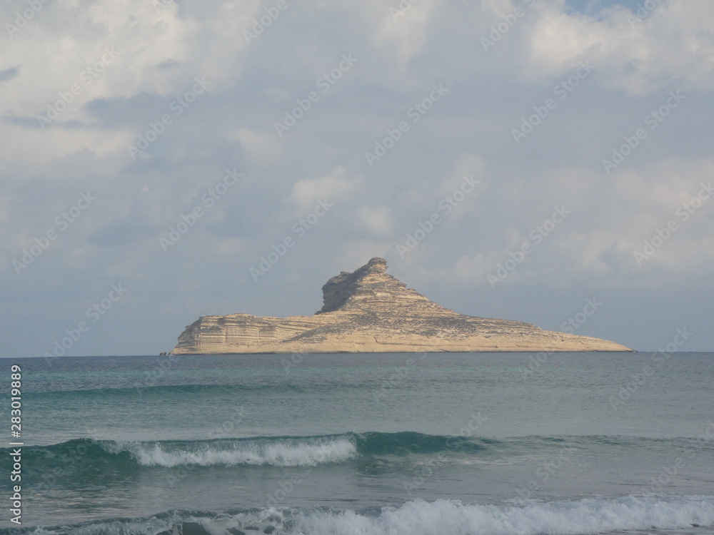Raf Raf (Tunisia) beach with small desert rocky island on the mediterranean sea waves on the shore