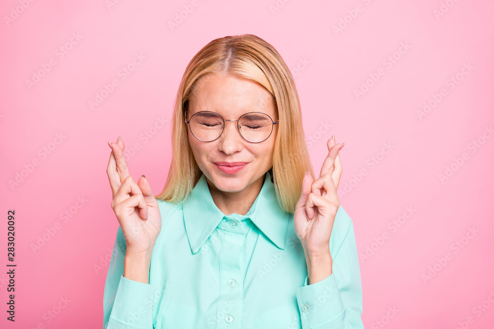 Close up photo of frightened lady in eyeglasses eyewear closing her eyes wearing teal turquoise shirt isolated over pink background Close up photo of frightened lady in eyeglasses eyewear closing her eyes wearing teal turquoise shirt isolated over pink background