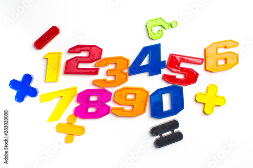 Heap of plastic colored arithmetic numbers close up.