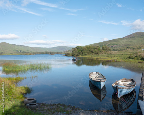 boats on lake cloonee lough on beara peninsula in ireland photo