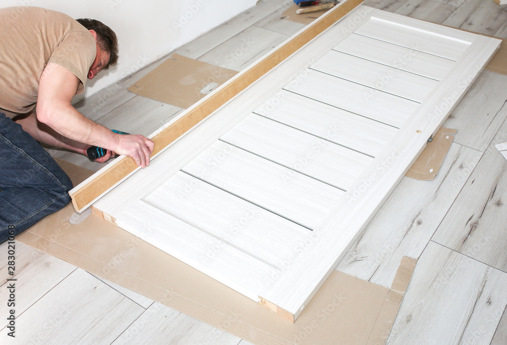 Man is installing the doors. Repair works. Maintenance in the apartment. Man is installing the doors. Repair works. Maintenance in the apartment.