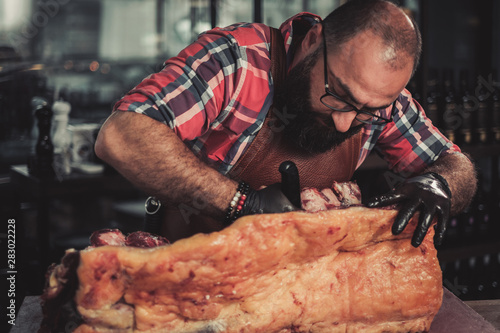 Chef cutting beef carcass in a restaurant