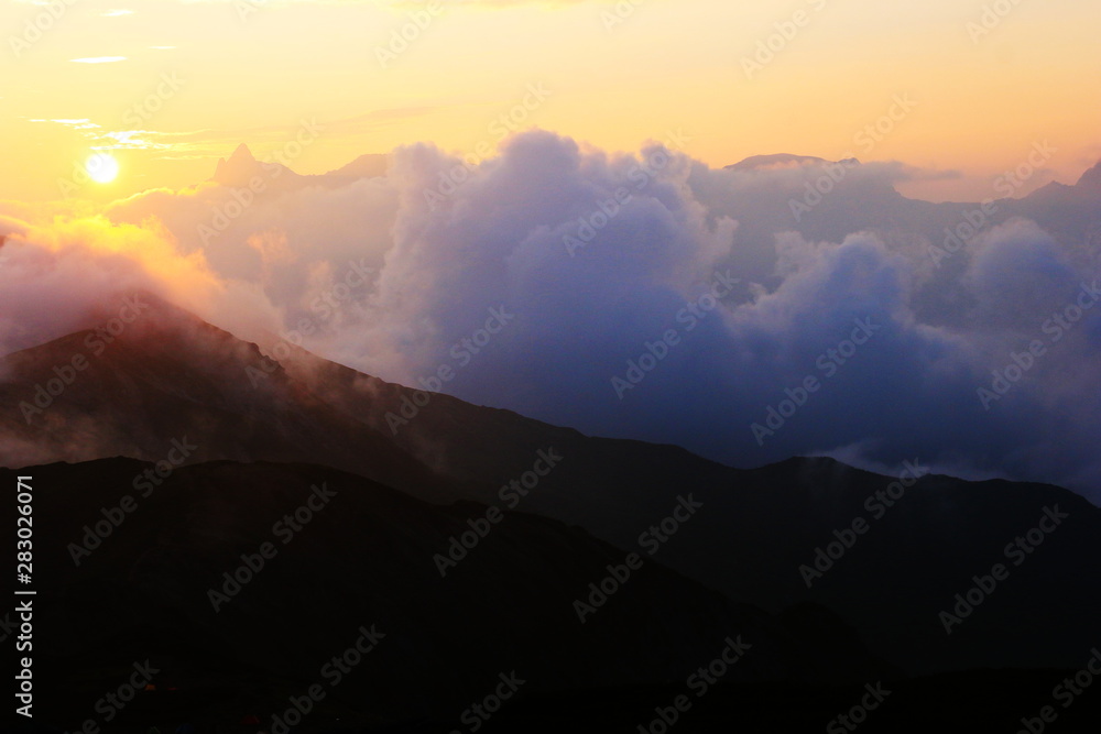 北アルプス笠ヶ岳　笠ヶ岳山頂から縦走路越しの朝陽と槍ヶ岳